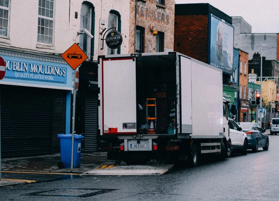 A delivery lorry unloading outside a plasterers’ merchant on a Dublin street
